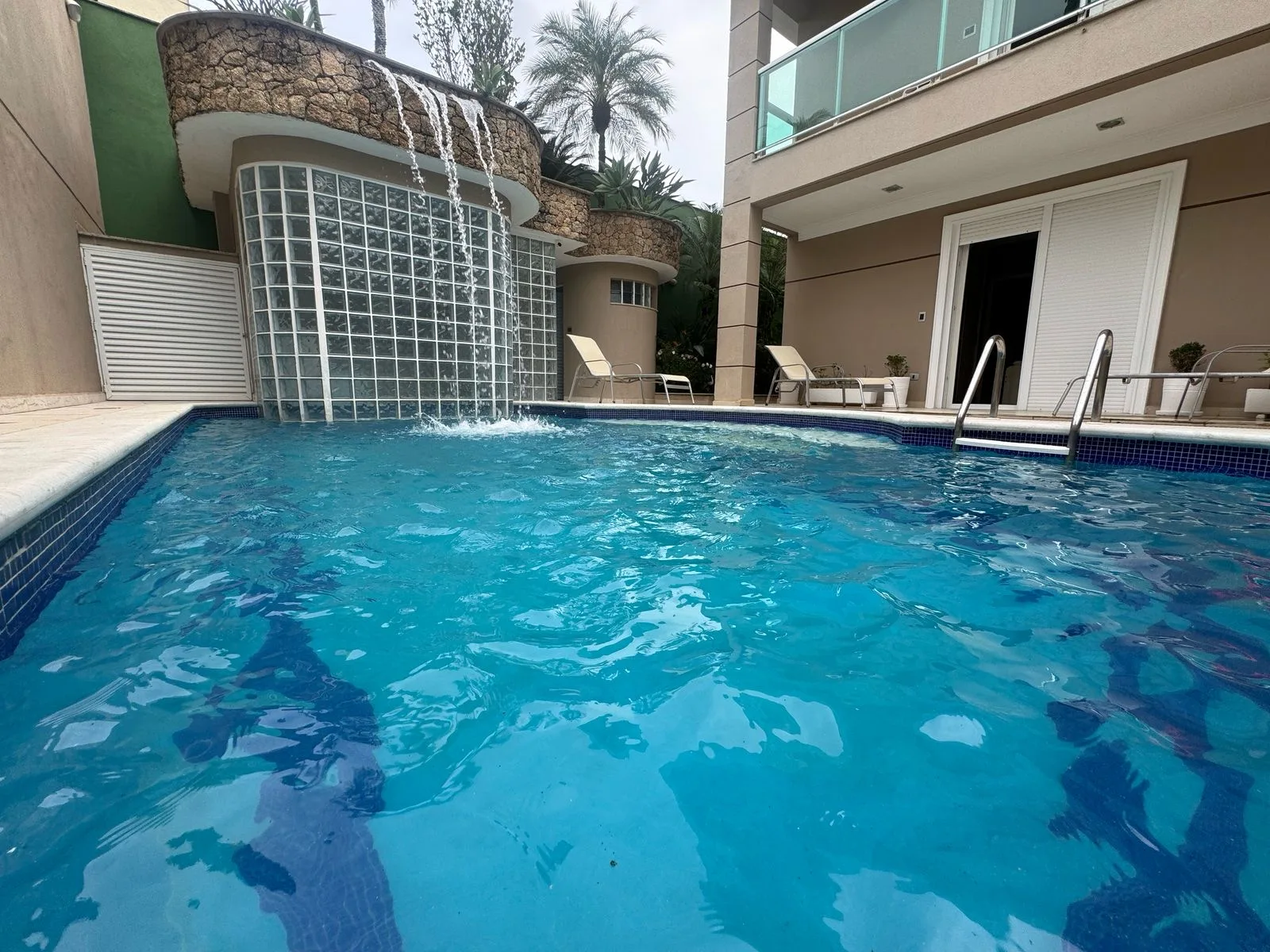 Piscina com cascata de pedra, vista dos fundos da casa