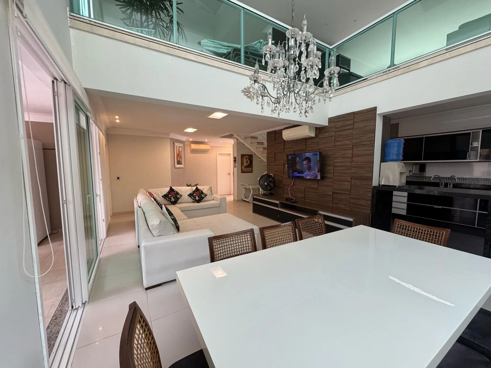 Sala de estar com pé-direito duplo e lustre de cristal
